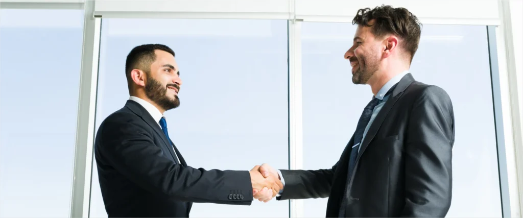 Smiling business professionals shaking hands, showcasing customer engagement and relationship-building strategies to attract and retain loyal customers in a competitive market. Ditrop Inc